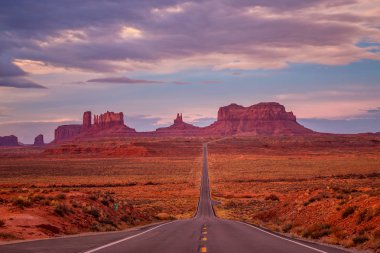Monument Valley, Arizona, ABD yakınındaki pembe, altın ve kırmızı renklerle şaşırtıcı gündoğumu.