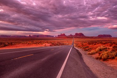 Monument Valley, Arizona, ABD yakınındaki pembe, altın ve kırmızı renklerle şaşırtıcı gündoğumu.