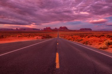 Monument Valley, Arizona, ABD yakınındaki pembe, altın ve kırmızı renklerle şaşırtıcı gündoğumu.