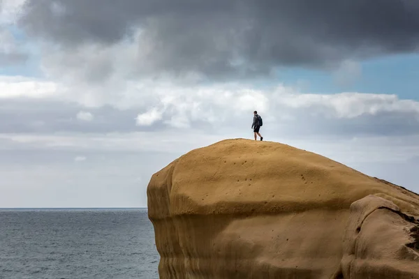 ニュージーランドの南の島 ダンディンのトンネルビーチ近くの石灰岩に登る男 — ストック写真