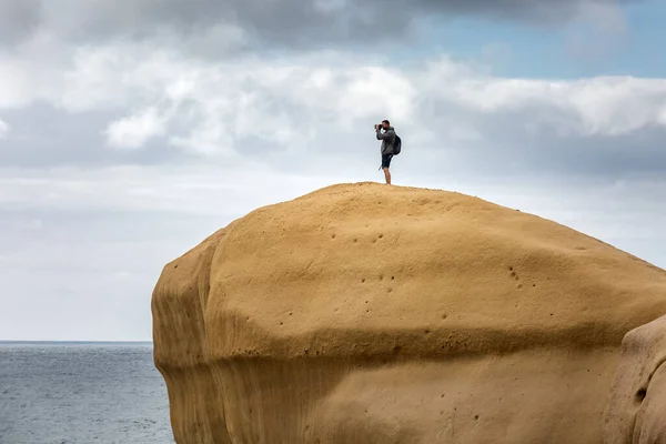 ニュージーランドの南の島 ダンディンのトンネルビーチ近くの石灰岩に登る男 — ストック写真