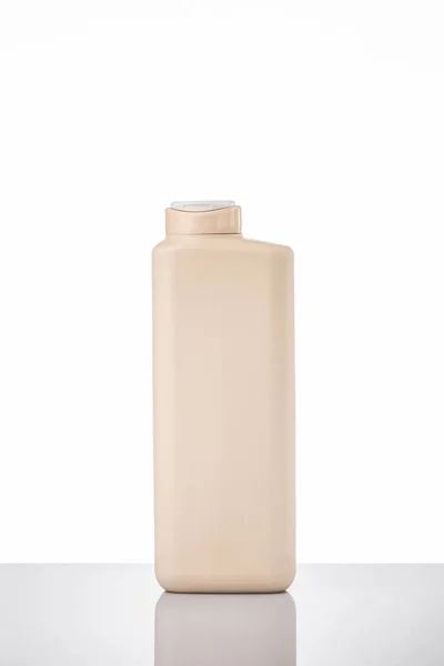 Cream bottle with detergent and cleaning supplies with reflection on the white background.