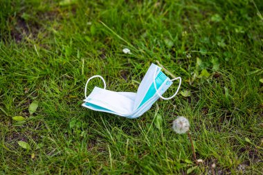 Yerdeki tıbbi maske. Tek kullanımlık yüz maskesi. Kullanılmış Cerrahi Maske Tesadüfen Pavement 'e atılmış. Kullanılmış Yüz Maskesi 'ni uygunsuz bir şekilde atılıyor. Çimenlerde Kayıp Yüz Maskesi.