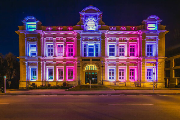 Neoclassical Oamaru Opera House building with night illumination.