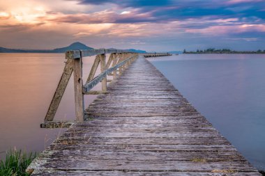 Gün batımında uzun pozlu eski ahşap iskele çekimi. Yeri, Yeni Zelanda 'nın Taupo bölgesindeki Tokaanu Rıhtımı..