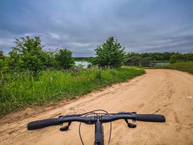 Bisikletin direksiyonu doğa arka planında. Seyahat, sağlıklı yaşam tarzı, kır yürüyüşü. Güneşli bir gün. Bisiklet sürme.