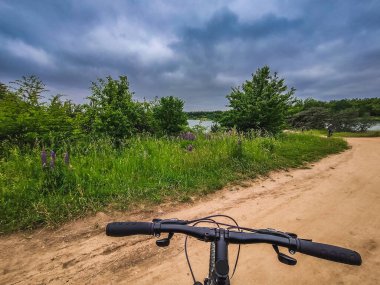 Bisikletin direksiyonu doğa arka planında. Seyahat, sağlıklı yaşam tarzı, kır yürüyüşü. Güneşli bir gün. Bisiklet sürme.