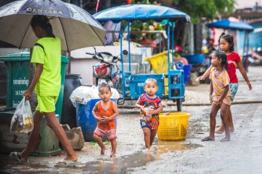 Tayland kırsalında yaşam tarzı olan çocuklar. Phuket, Tayland 'ın kırsal kesimlerinde su sıçratmaca oynayan çocuklar. Phuket, Tayland - 28 Mart 2017.