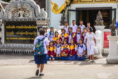 Tayland 'daki bir grup çocuk, okuldaki şehir direğinin yanında fotoğraf çekiyor. Chiang Mai, Tayland - 09 Kasım 2017.