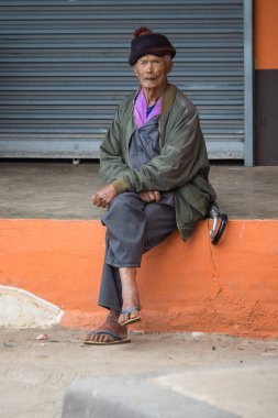 Yaşlı adam ormanda yolun kenarında oturur. Doi Mae Salong, Tayland - 14 Kasım 2017.