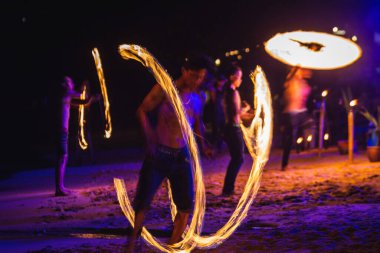 Fireshow 'un etrafını sarın. Tayland sahilindeki inanılmaz ateş şovunda. Koh Tao, Tayland - 30 Kasım 2017.