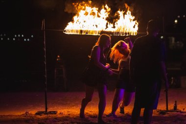 Turistler geceleri Tayland sahillerinde ateş altında geçmeye çalışırlar. Koh Tao, Tayland - 30 Kasım 2017.