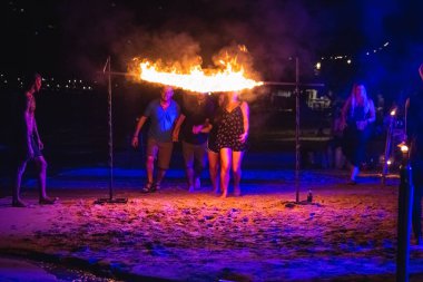 Turistler geceleri Tayland sahillerinde ateş altında geçmeye çalışırlar. Koh Tao, Tayland - 30 Kasım 2017.