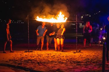 Turistler geceleri Tayland sahillerinde ateş altında geçmeye çalışırlar. Koh Tao, Tayland - 30 Kasım 2017.