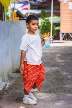 Genç okul çocuğu dışarıda buz gibi içecek içiyor. Koh Tao, Tayland - 01 Aralık 2017.