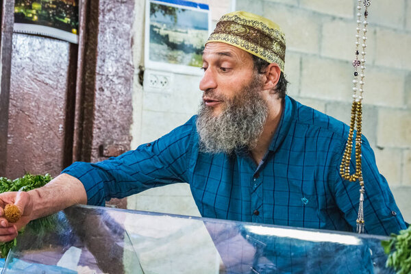 Authentic old muslim seller in The Old City market situated between the Jewish Quarter and the Muslim Quarter. Offers free falafel. Souvenir shops in Jerusalem. Jerusalem, Israel - April 19 2018