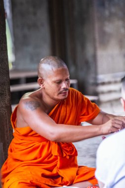 Turuncu cüppeli keşiş Angkor Wat Tapınağında dua ediyor. Siem Reap, Kamboçya - 19 Kasım 2017.