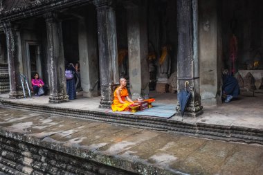 Turuncu cüppeli keşiş Angkor Wat Tapınağında dua ediyor. Siem Reap, Kamboçya - 19 Kasım 2017.