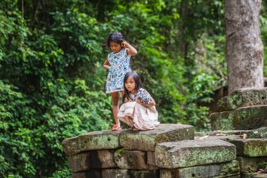 Yerel çocuklar Angkor Wat harabelerinde oynuyorlar. Siem Reap, Kamboçya - 19 Kasım 2017.
