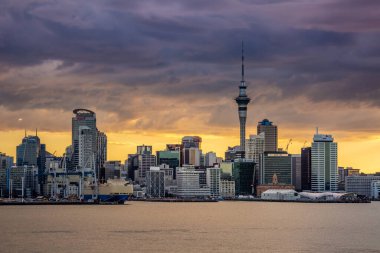 Auckland City, şehir merkezi ve Yeni Zelanda 'nın ikonik simgesi Auckland Sky Tower ile birlikte gün batımından sonra ufuk çizgisi üzerindedir. Auckland, Yeni Zelanda - 17 Aralık 2017.