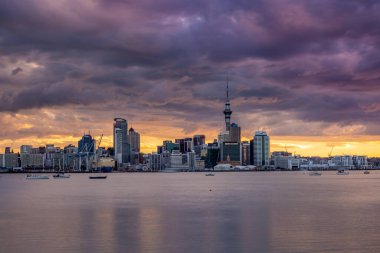 Auckland City, şehir merkezi ve Yeni Zelanda 'nın ikonik simgesi Auckland Sky Tower ile birlikte gün batımından sonra ufuk çizgisi üzerindedir. Auckland, Yeni Zelanda - 17 Aralık 2017.