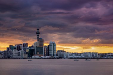 Auckland City, şehir merkezi ve Yeni Zelanda 'nın ikonik simgesi Auckland Sky Tower ile birlikte gün batımından sonra ufuk çizgisi üzerindedir. Auckland, Yeni Zelanda - 17 Aralık 2017.