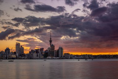 Auckland City, şehir merkezi ve Yeni Zelanda 'nın ikonik simgesi Auckland Sky Tower ile birlikte gün batımından sonra ufuk çizgisi üzerindedir. Auckland, Yeni Zelanda - 17 Aralık 2017.