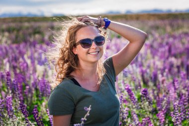 Lupin tarlasında Tekapo Gölü yakınlarında çiçek açan kız, Yeni Zelanda. Tekapo, Yeni Zelanda - 24 Aralık 2017.