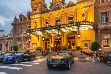 Gece Monte-Carlo Kumarhanesi, Paris Oteli, gece aydınlanması, lüks arabalar, oyuncular, turistler, çeşmeler, Cafe de Paris. Monako, Monako - 29 Temmuz 2016.