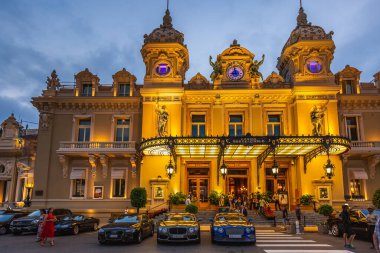 Gece Monte-Carlo Kumarhanesi, Paris Oteli, gece aydınlanması, lüks arabalar, oyuncular, turistler, çeşmeler, Cafe de Paris. Monako, Monako - 29 Temmuz 2016.