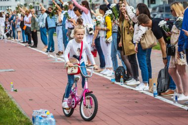 Minsk, Belarus 'ta çalınan cumhurbaşkanlığı seçimlerine karşı düzenlenen barışçıl protestolarda bisikletli çocuk ve elinde çiçek tutan insanlar