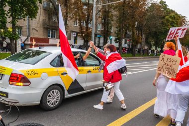 Belarus 'ta Beyaz Rusya, Minsk' teki hileli cumhurbaşkanlığı seçimlerine karşı barışçıl protestolar sırasında yolcularla birlikte bir araç sürücüsü. Minsk, Belarus - 30 Ağustos 2020.