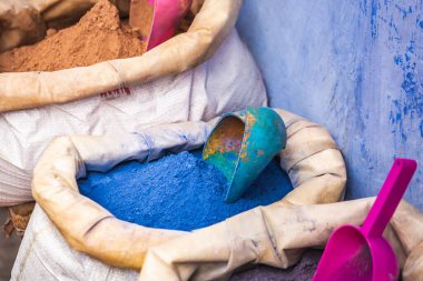 Şef Chaouen 'de satılık çuvallarda renkli toz pigmentleri. Fas 'ta mavi duvarları olan mavi bir şehir..