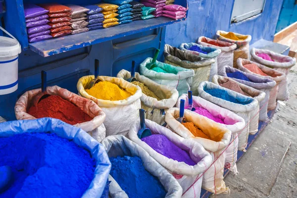 Şef Chaouen 'de satılık çuvallarda renkli toz pigmentleri. Fas 'ta mavi duvarları olan mavi bir şehir..