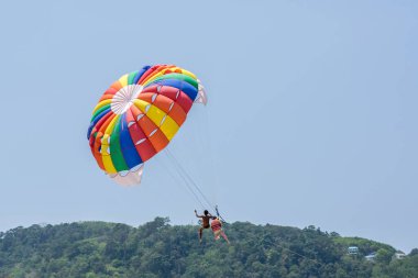 Phuket, Tayland 'da Patong plajında paraşütle uçan turistler.
