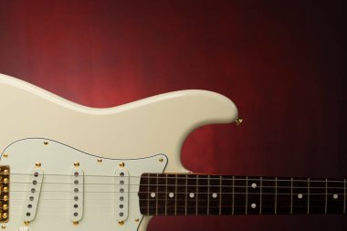 Olimpiyat beyaz gitarını kırmızı bir gradyan arkaplanda kapat