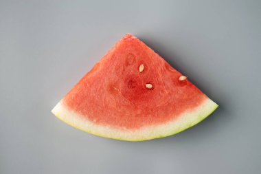 Gri arka planda duran dilimlenmiş karpuz meyvesi