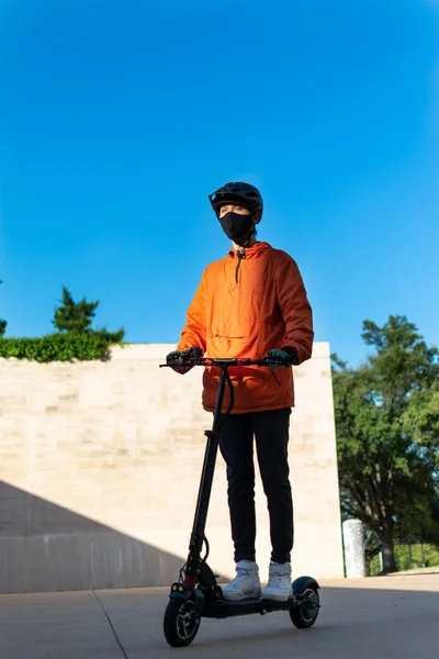 Jonge Jongen Draagt Een Oranje Jas Zwart Masker Rijdt Elektrische — Stockfoto