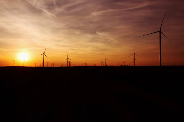 Turbinas eólicas sobre el cielo al atardecer generando electricidad — Foto de Stock