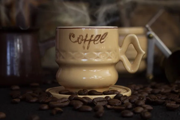 Kaffeetasse, Kanne, Mühle mit Kaffeebohnen auf rustikaler Holzoberfläche — Stockfoto