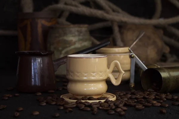 Kaffeetasse, Kanne, Mühle mit Kaffeebohnen auf rustikaler Holzoberfläche — Stockfoto
