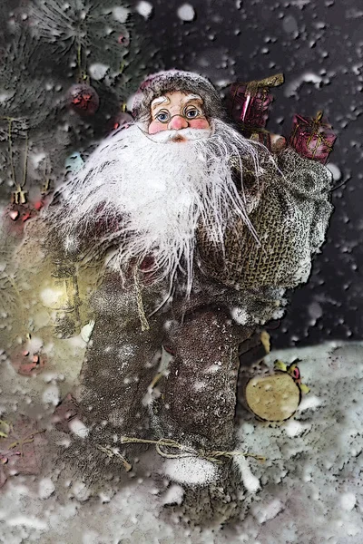 Papai Noel ao ar livre ao lado da árvore de Natal na queda de neve levando presentes para crianças — Fotografia de Stock