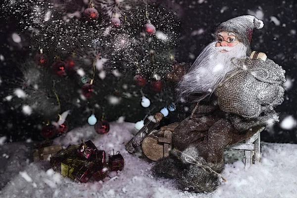 Papai Noel ao ar livre ao lado da árvore de Natal na queda de neve levando presentes para crianças — Fotografia de Stock