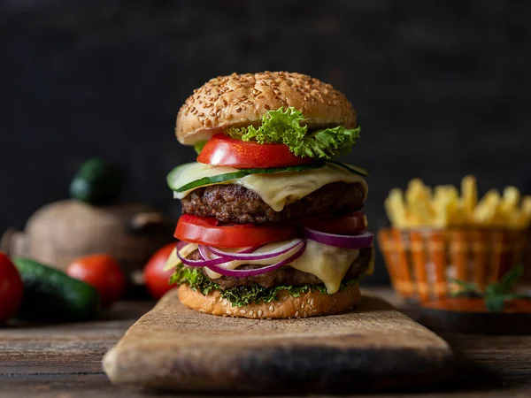 Hamburger Domates Soğan Salatalık Marul Eritme Peyniri Arkaplanda Patates Kızartması — Stok fotoğraf