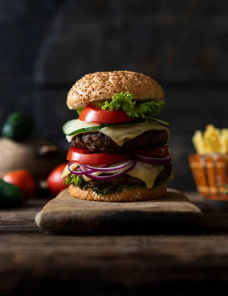 Hamburger Pomidorami Cebulą Ogórkiem Sałatą Topiącym Się Serem Podawany Drewnianej — Zdjęcie stockowe