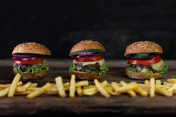Hamburgery Pomidorami Cebulą Ogórkiem Sałatą Topiącym Się Serem Frytkami Serwowane — Zdjęcie stockowe