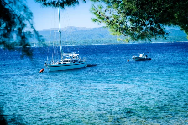 Hırvatistan - Yazın güneşli bir günde yat, mavi deniz, arka planda dağlar ve ağaçlar