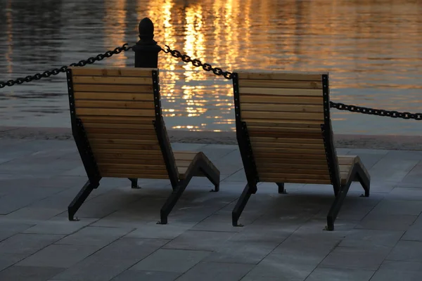 Sillas Madera Terraplén Junto Agua Con Vistas Reflejo Resplandor Del — Foto de Stock