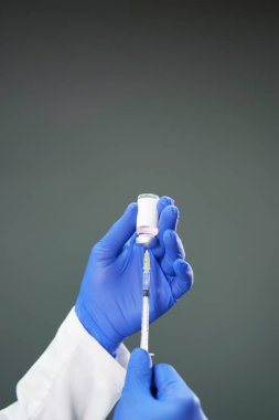 Doktorun eli koronavirüs aşısı hazırlıyor. Mavi lateks eldivenli el covid 19 aşısını hazırlar. Bakış açısı. Coronavirus için yeni aşı kavramı.