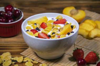 Masada mısır gevreği, çilek, kiraz, şeftali ve yoğurt var..